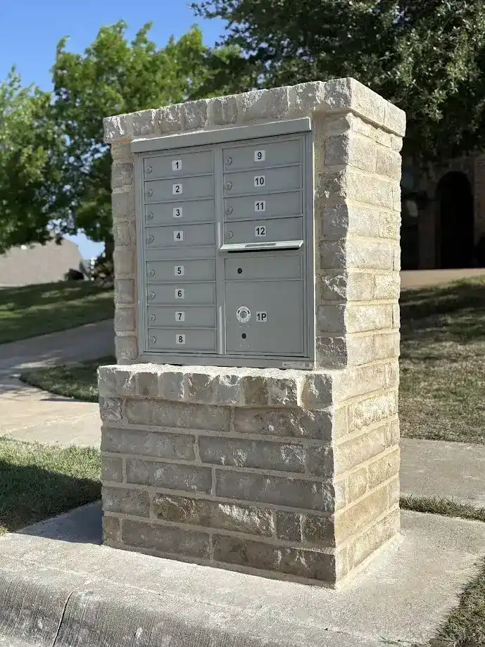 HOA community CBU cluster box unit rebuilt with Austin stone surround and cast stone cap