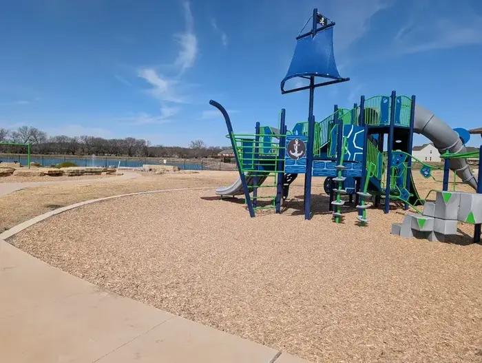 Pirate ship themed commercial playground with slides and climbing features on wood fiber surfacing